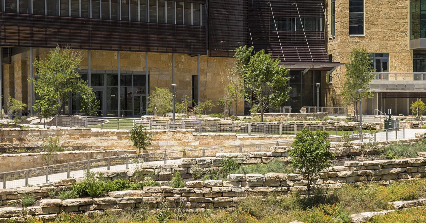 A building with stone steps and trees in front of it.