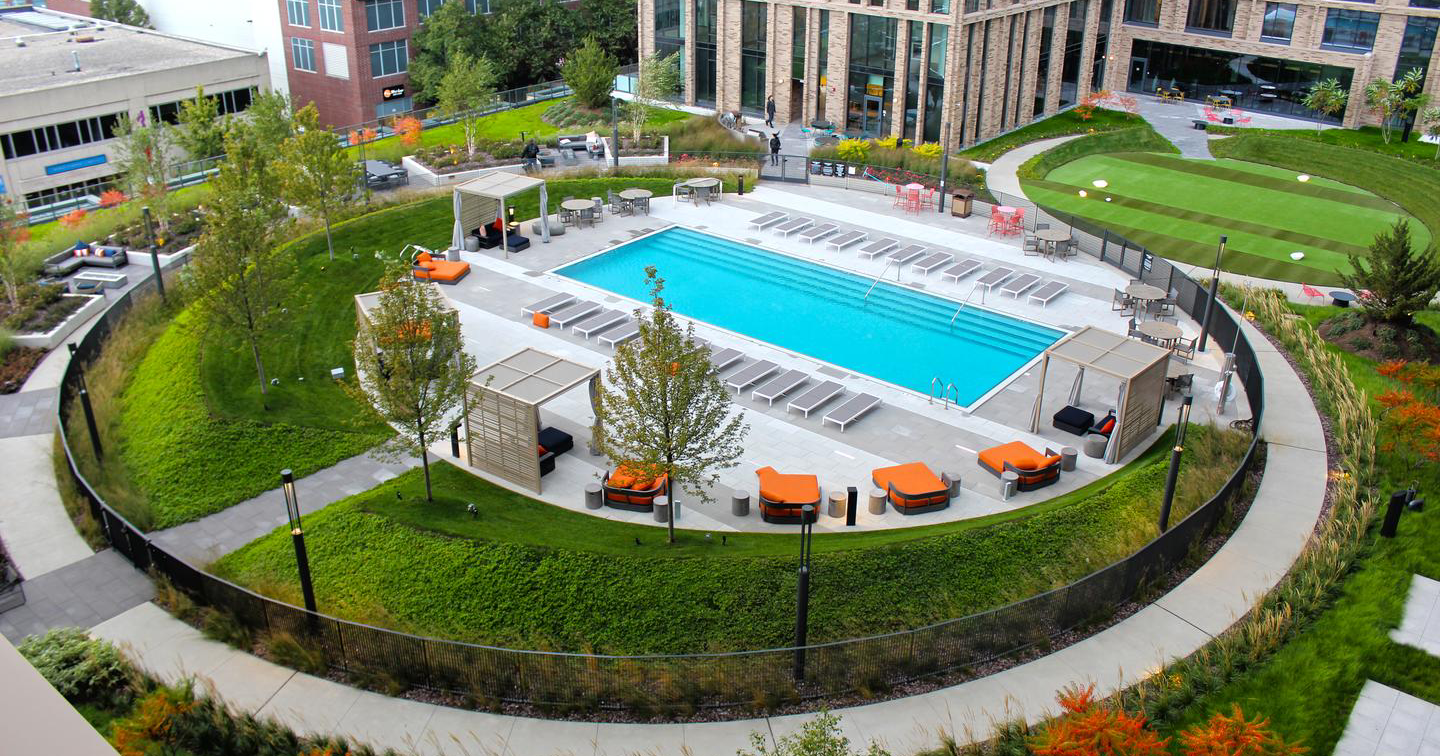 A large pool surrounded by grass and trees.